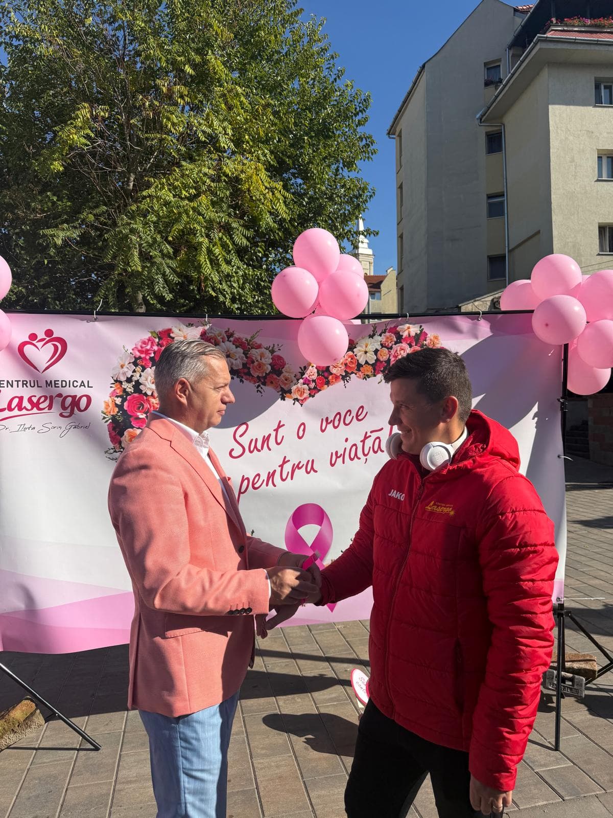 Dr. Iluță Sorin Gabriel dând mâna cu un participant, în fața bannerului „Sunt o voce pentru viață!”