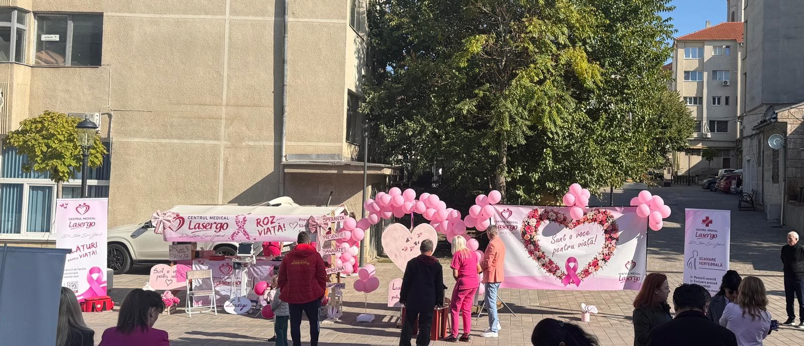 Standul Centrului Medical Lasergo la campania „Roz pentru viață”, cu baloane roz și bannerul „Sunt o voce pentru viață!”