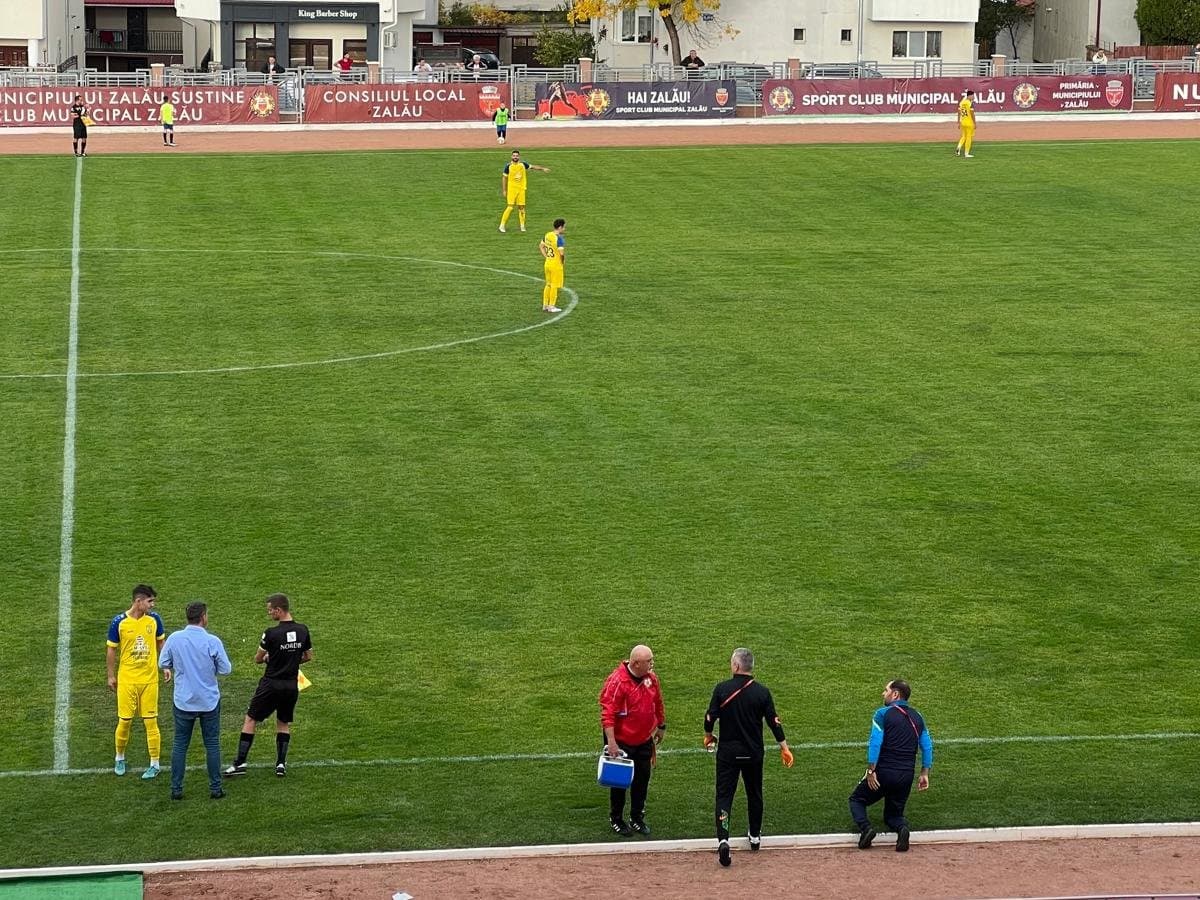 Stadionul din Zalău în timpul unui meci, cu echipa medicală pe marginea terenului