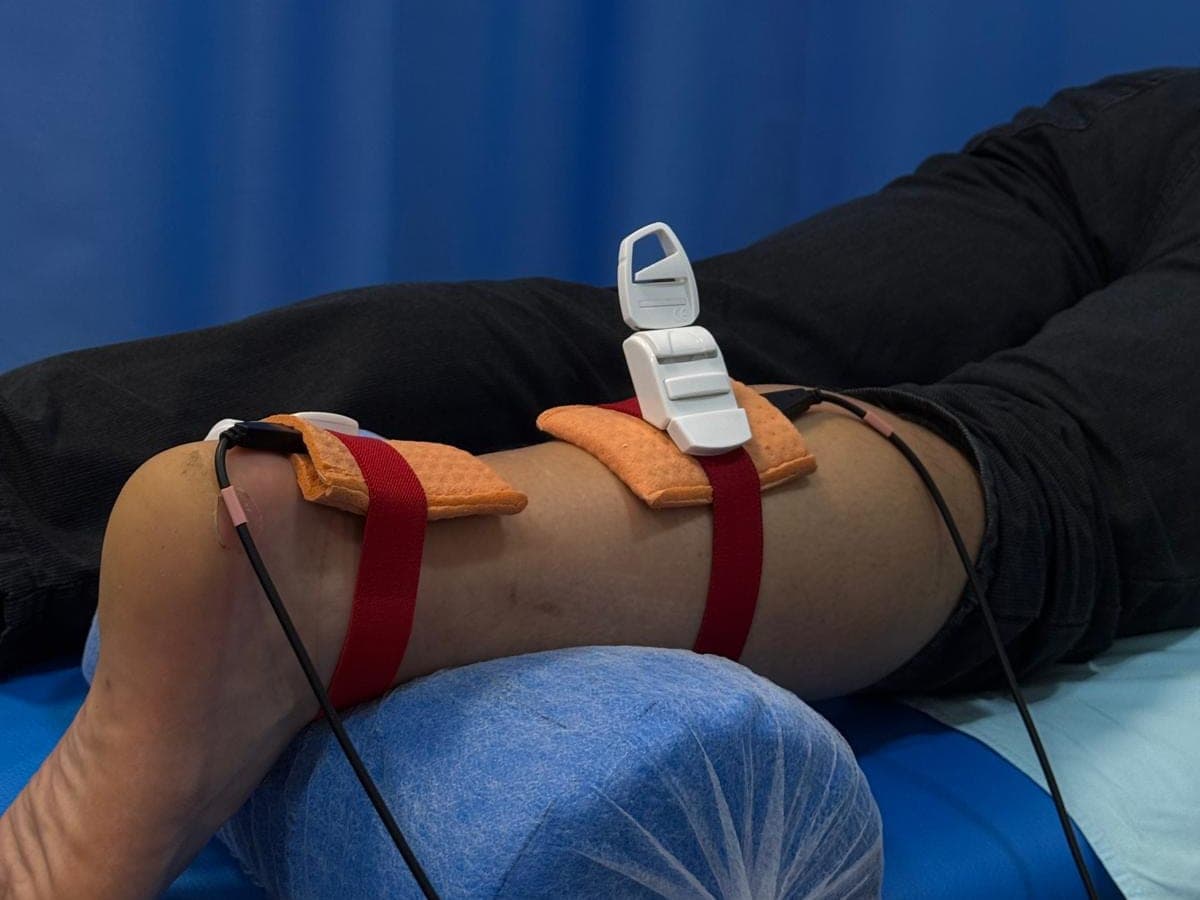 Electrozi prinși cu benzi pe gamba unui pacient, pentru curent interferențial