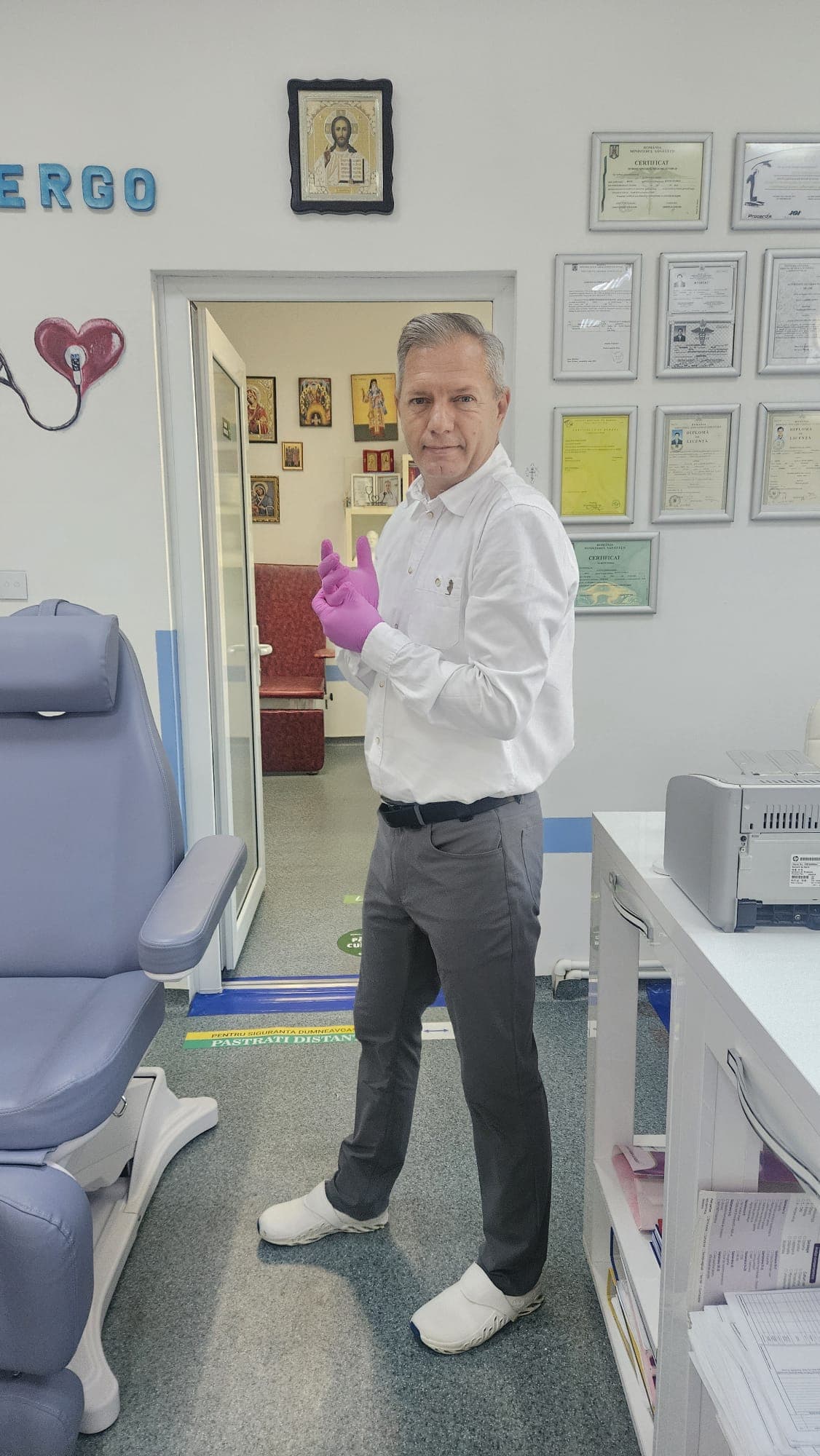 Dr. Iluță Sorin Gabriel în cabinet, lângă diplomele și certificatele sale