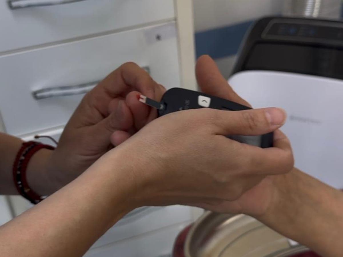 Picătura de sânge din degetul pacientului e pusă pe banda glucometrului